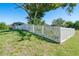 Lush backyard featuring a charming white picket fence and mature landscaping at 6387 Shalimar St, Port Charlotte, FL 33981