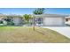 Charming single-story home featuring a manicured lawn, well-maintained landscaping, and an attached two-car garage at 6387 Shalimar St, Port Charlotte, FL 33981