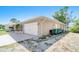 Exterior view of a two-car garage attached to a home with a paved driveway and manicured landscaping at 6387 Shalimar St, Port Charlotte, FL 33981
