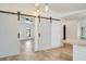 Kitchen island featuring light-colored stone countertops and stylish barn doors to the dining room at 6387 Shalimar St, Port Charlotte, FL 33981