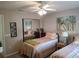 Comfortable bedroom with twin beds, mirrored closet, ceiling fan, and tropical artwork at 6821 Fairview Ter # 6821, Bradenton, FL 34203