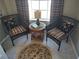 Cozy sitting area with wicker chairs, patterned cushions, and a round accent table near a bright window at 6821 Fairview Ter # 6821, Bradenton, FL 34203