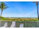 Expansive beach view from lounge area with palm trees and white picket fence for relaxed coastal living at 7000 Gulf Dr # 215, Holmes Beach, FL 34217