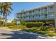 Charming multi-story condo building with white railings, lush landscaping, and convenient covered parking at 7000 Gulf Dr # 215, Holmes Beach, FL 34217