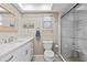 Bathroom featuring a glass shower, white vanity with quartz countertop, framed mirror, and a toilet at 7122 11Th W Ave, Bradenton, FL 34209