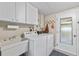 Bright laundry room featuring a sink, washer, dryer, and storage cabinets at 7122 11Th W Ave, Bradenton, FL 34209