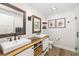 Bathroom featuring double vanities, wood countertops, white cabinets, and a glass shower at 7150 Richardson Rd, Sarasota, FL 34240