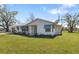 Charming single-story home with a metal roof, blue awnings, and well-maintained lawn, showcasing classic curb appeal at 7150 Richardson Rd, Sarasota, FL 34240