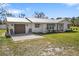 Single-story home featuring a metal roof, garage, and well-maintained lawn, perfect for comfortable living at 7150 Richardson Rd, Sarasota, FL 34240
