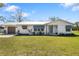 Charming single-story home featuring a metal roof, attached garage, blue awnings, and well-manicured lawn at 7150 Richardson Rd, Sarasota, FL 34240