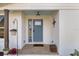 Inviting front porch features a blue door, a hanging plant, and a decorative accent, enhancing curb appeal at 7150 Richardson Rd, Sarasota, FL 34240