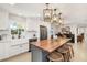 Stylish kitchen features white cabinetry, stainless steel appliances, butcher block island, and modern lighting fixtures at 7150 Richardson Rd, Sarasota, FL 34240