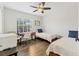 Bright bedroom featuring two twin beds, hardwood floors, and a desk next to a window at 7612 4Th Avenue Nw Dr, Bradenton, FL 34209