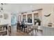 Bright dining room featuring wood floors, modern wood table, neutral curtains and a blue exterior door at 7612 4Th Avenue Nw Dr, Bradenton, FL 34209