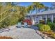 Inviting outdoor seating area with two blue Adirondack chairs surrounded by lush tropical landscaping at 7612 4Th Avenue Nw Dr, Bradenton, FL 34209