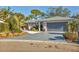 Charming home featuring a gray driveway, a well-manicured lawn, and stylish landscaping at 7612 4Th Avenue Nw Dr, Bradenton, FL 34209