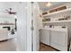 Convenient laundry room with washer, dryer, and built-in shelving and easy access to the living room at 7612 4Th Avenue Nw Dr, Bradenton, FL 34209