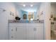 Bathroom vanity with framed nautical art and a view into the toilet room at 1080 Peppertree W Ln # 602, Sarasota, FL 34242
