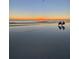 Gorgeous sunset on beach with two chairs and water reflecting the sky and people at 1080 Peppertree W Ln # 602, Sarasota, FL 34242