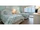 Bright bedroom features two twin beds, a private balcony with ocean views, and modern coastal decor at 1080 Peppertree W Ln # 602, Sarasota, FL 34242