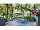 Community grill area with tables and chairs, shaded by mature trees and landscaping at 1080 Peppertree W Ln # 602, Sarasota, FL 34242