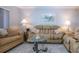 Comfortable living room featuring a plush beige sofa and a glass coffee table at 1080 Peppertree W Ln # 602, Sarasota, FL 34242