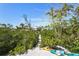 Scenic backyard with lush greenery, a sandy path, and colorful kayaks at 111 Faubel St, Sarasota, FL 34242