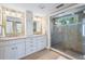 Bathroom with granite countertops, and sinks, decorative mirrors, and mosaic tiled shower at 111 Faubel St, Sarasota, FL 34242