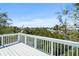 A spacious deck with white railings provides a tranquil view of the nearby water and trees at 111 Faubel St, Sarasota, FL 34242