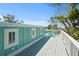 A deck with white railings offers blue lounge chairs and a view of the surrounding lush greenery at 111 Faubel St, Sarasota, FL 34242