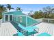 The spacious outdoor deck features a comfortable seating area and lovely turquoise exterior siding at 111 Faubel St, Sarasota, FL 34242