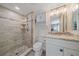Updated bathroom featuring a tiled shower with glass door and vanity with storage at 1250 N Portofino Dr # 203, Sarasota, FL 34242