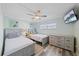 Charming bedroom with twin beds, coastal decor, and a ceiling fan at 1250 N Portofino Dr # 203, Sarasota, FL 34242
