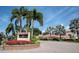 Attractive community entrance with manicured landscaping, palm trees, and the Siesta Harbor sign at 1250 N Portofino Dr # 203, Sarasota, FL 34242