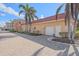 Exterior view of a garage and community building, surrounded by a brick driveway and palm trees at 1250 N Portofino Dr # 203, Sarasota, FL 34242