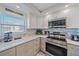 Kitchen featuring modern stainless appliances, granite countertops, custom cabinets, and mosaic backsplash at 1250 N Portofino Dr # 203, Sarasota, FL 34242