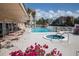 Relaxing community pool and spa, surrounded by tables, chairs, and lush landscaping at 1250 N Portofino Dr # 203, Sarasota, FL 34242