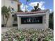 Close-up of the Siesta Harbor sign surrounded by flowers, adding curb appeal at 1250 N Portofino Dr # 203, Sarasota, FL 34242