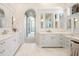 A spacious bathroom with dual sinks, white cabinets and an arched doorway to an adjacent room at 1378 Harbor Dr, Sarasota, FL 34239