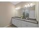 Bathroom with granite countertop, dual sinks, white cabinetry, and a large mirror at 13804 Camden Crest Ter, Lakewood Ranch, FL 34211