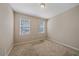Carpeted bedroom featuring two windows, neutral walls, and ample natural light at 13804 Camden Crest Ter, Lakewood Ranch, FL 34211