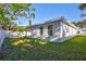 Side view of the house showcasing the lush green lawn and fenced backyard at 1422 19Th St, Sarasota, FL 34234