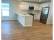 Modern kitchen with stainless steel appliances, white cabinets, quartz countertops, and wood-look floors at 1426 19Th St, Sarasota, FL 34234