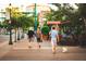 A sunny street view showcasing people strolling with a dog on a brick-paved sidewalk at 1426 19Th St, Sarasota, FL 34234
