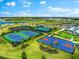 Aerial view of community basketball and tennis courts nestled among manicured landscaping and waterways in a beautiful neighborhood at 15225 Lyla Ter, Bradenton, FL 34211