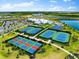 Aerial view of resort-style community tennis and basketball courts with clubhouse and picturesque waterway running through it at 15225 Lyla Ter, Bradenton, FL 34211