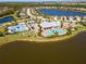 Community aerial showing the lake, clubhouse, pool, tennis courts, and lush landscaping at 18013 Polo Trl, Bradenton, FL 34211