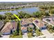 Aerial view of home showcasing a screened-in lanai, beautiful landscaping, and serene lake views at 18013 Polo Trl, Bradenton, FL 34211