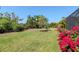 An impressive backyard featuring vibrant flowers and verdant grass with space for entertainment at 18013 Polo Trl, Bradenton, FL 34211