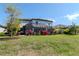 Spacious backyard featuring a screened-in lanai, lush landscaping, and mature trees, perfect for outdoor living at 18013 Polo Trl, Bradenton, FL 34211